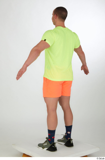 Joel a-pose dressed green sneakers orange shorts sports standing whole…